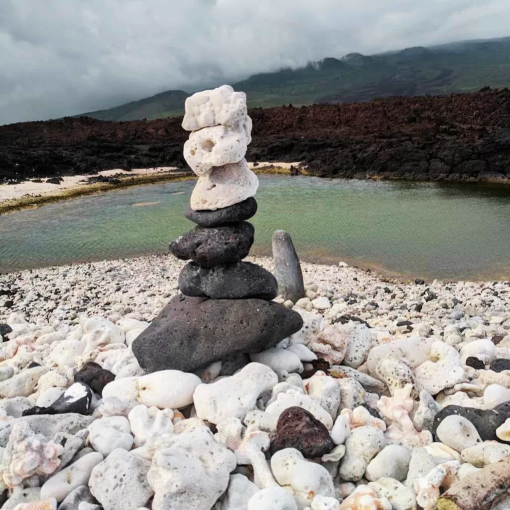 black and white rocks piled vertically over a rocky beach symbolizing balance